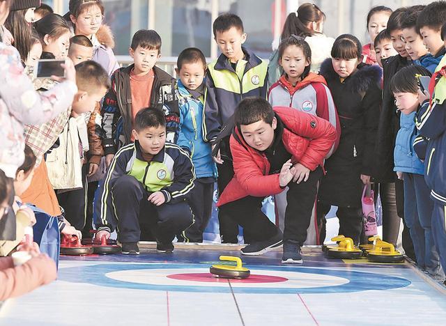 在省首屆冰雪運動會上，孩子們體驗陸地冰壺。